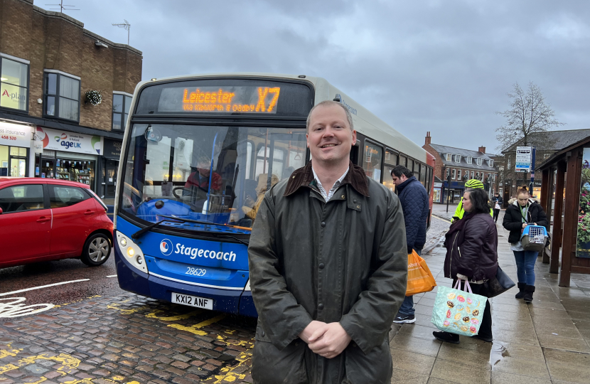 Neil O'Brien MP next to a local bus