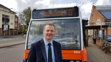 Neil O'Brien MP next to a local bus